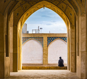 Rear view of man walking in historical building