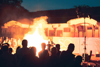 Group of people by bonfire at night