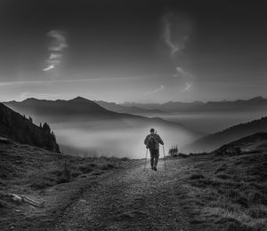 Rear view of man on mountain against sky