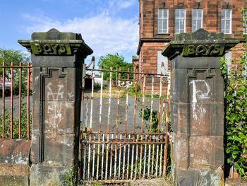 Text on metal fence against building