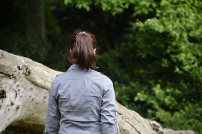 Rear view of woman standing against trees