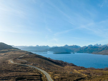 Scenic view of sea and mountains against sky