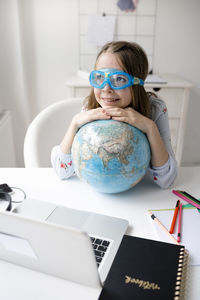 Portrait of cute girl wearing eyeglasses on table