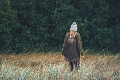 Rear view of woman walking on field