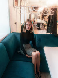Portrait of woman sitting on sofa at home