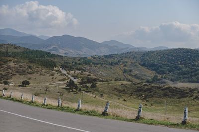 Road amidst field against sky