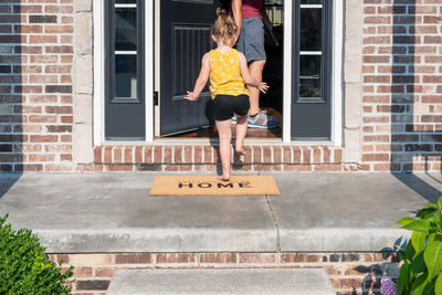 Full length of a girl jumping against building