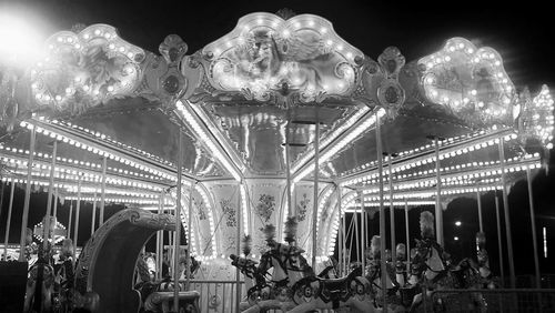 Low angle view of illuminated carousel at night