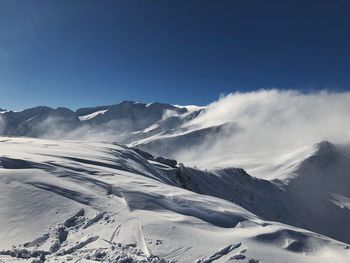 Scenic view of snowcapped mountains against clear sky