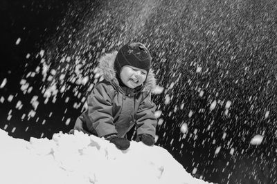 Little boy playing snowballs.