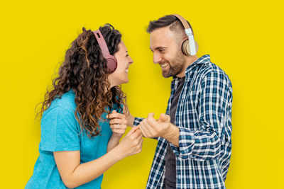 Side view of a man holding yellow camera