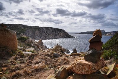 Rock formations on shore against sky