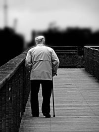 Rear view of woman walking on boardwalk