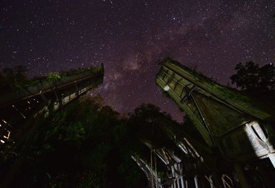 Low angle view of built structures against star field at night