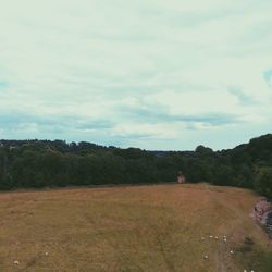 Scenic view of field against cloudy sky