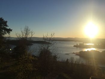 Scenic view of lake against clear sky during sunset