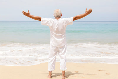 Rear view of man standing at beach