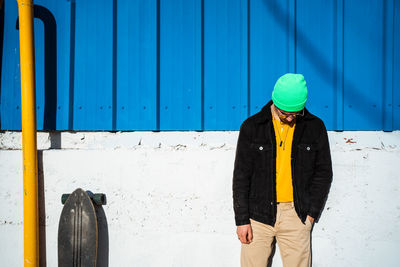 Full length of woman standing against blue wall