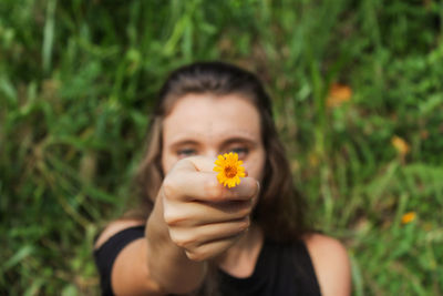 Portrait of woman holding yellow flower