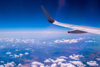 Aerial view of airplane flying over blue sky