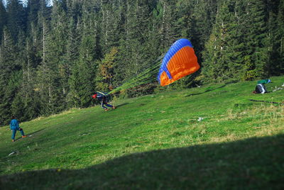 Person running with parachute on grassy field