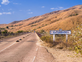 Road signs on landscape against sky