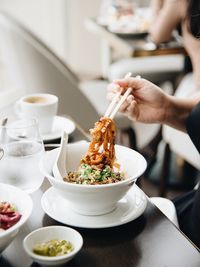 Cropped hand having food at table