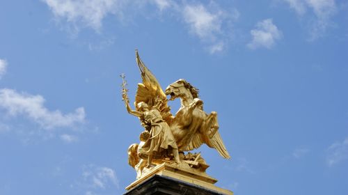 Low angle view of angel statue against sky