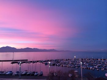 Scenic view of river and mountains against sky at sunset