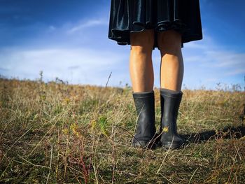 Low section of woman standing on field