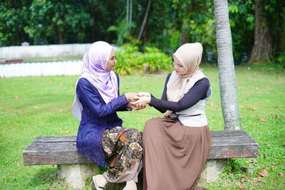 Woman sitting on bench in park