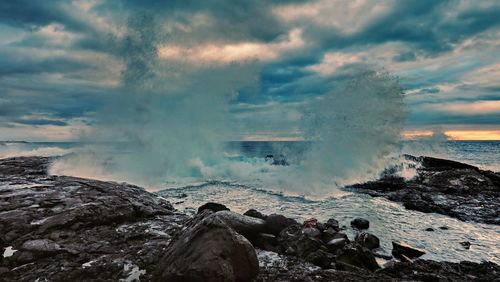 Panoramic shot of rocks by sea against sky