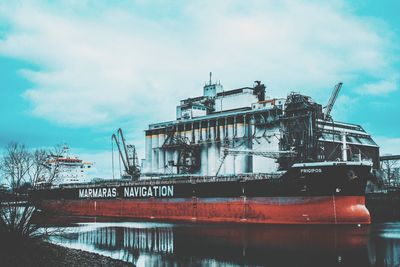 Low angle view of ship moored at harbor against sky