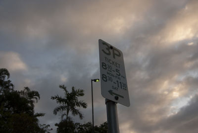 Low angle view of road sign against cloudy sky