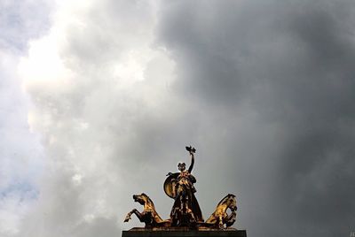 Low angle view of statue against cloudy sky