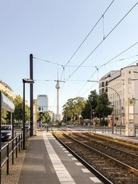 Railroad tracks in city against clear sky