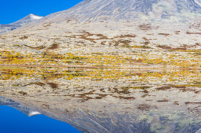 Mountain reflected in still lake, rondane national park, norway.