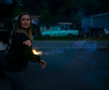 Woman standing against illuminated water