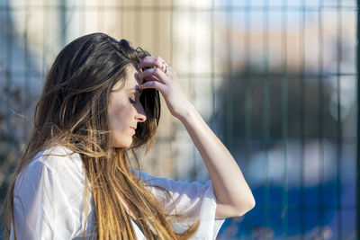 Close-up of woman standing against fence