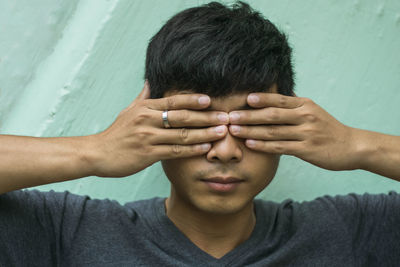 Portrait of boy covering face with hands