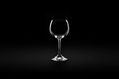 Close-up of wineglass on table against black background