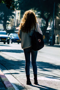 Rear view of woman walking on street in city