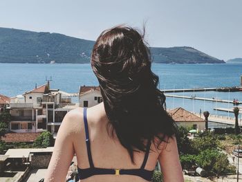 Rear view of woman looking at sea against sky