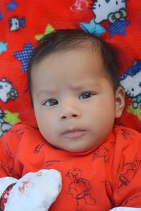 High angle portrait of cute baby boy lying on bed