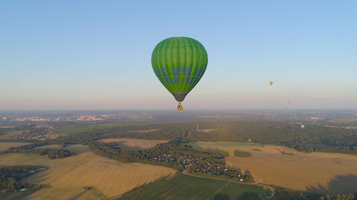 Aerial view hot air balloon in sky over fields in countryside, beautiful sky and sunset. 