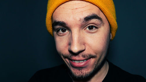 Portrait of man wearing hat against black background