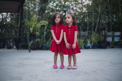 Twin sisters standing in backyard
