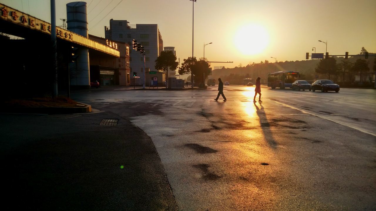 building exterior, architecture, built structure, sunset, street, sun, city, transportation, car, sunlight, land vehicle, mode of transport, city street, city life, road, sky, sunbeam, lens flare, silhouette