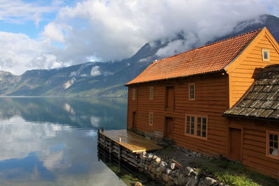 Houses by lake against sky