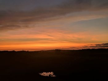 Scenic view of silhouette landscape against orange sky